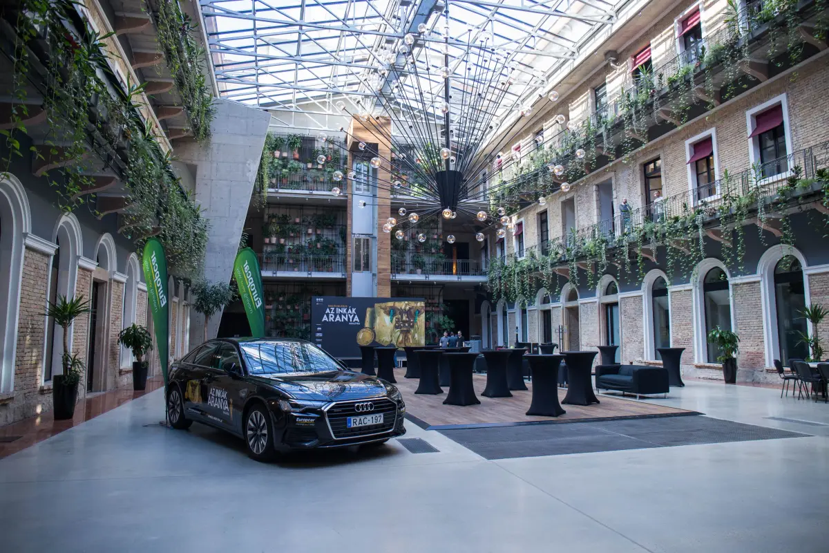 Glass-roofed atrium set up for an event with cocktail tables