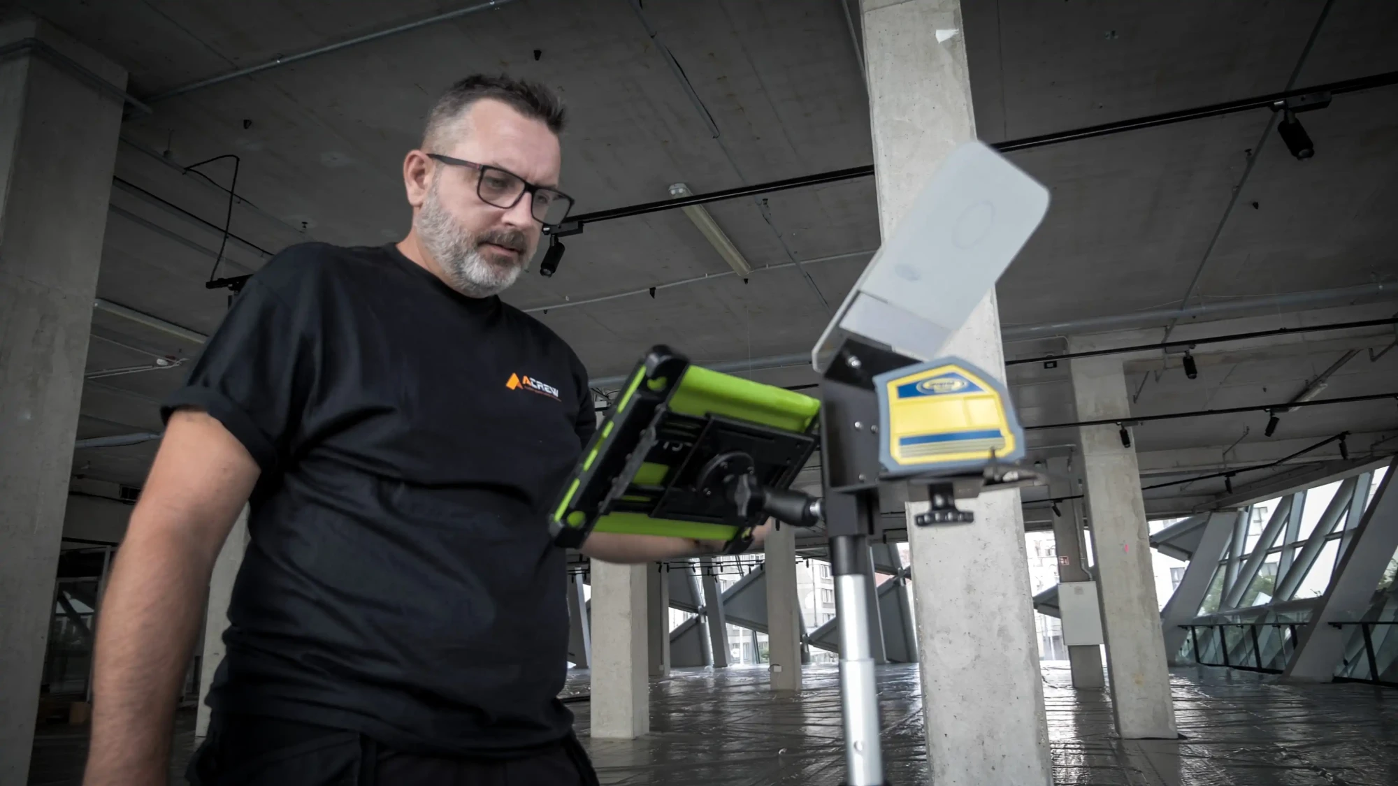 Acrew munkatárs lézeres szintezőt állít be egy betonvázas épületben